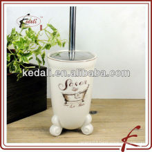 white ceramic and decal toilet brush with base